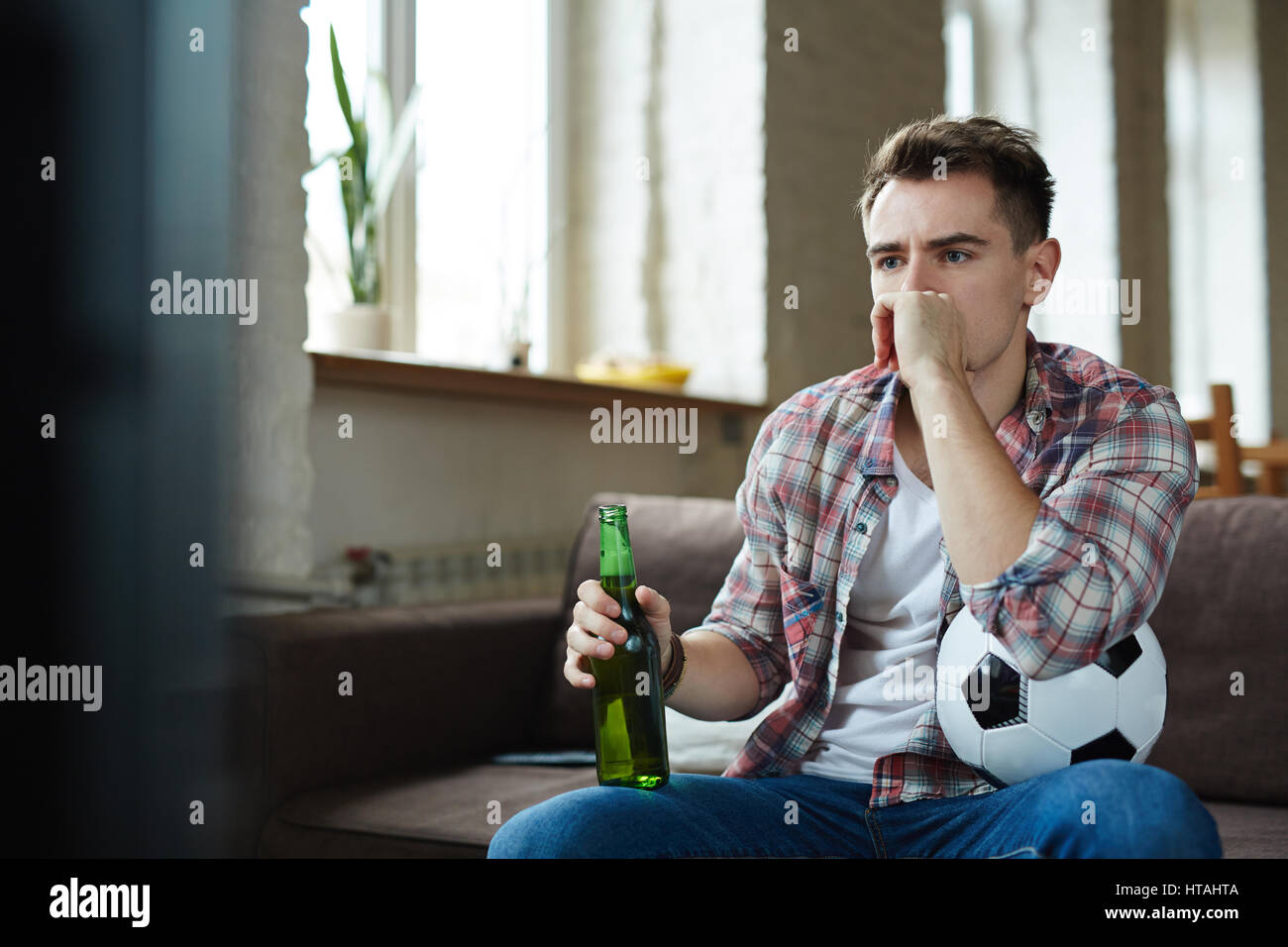 Stressed guy watching culmination of football match Stock Photo