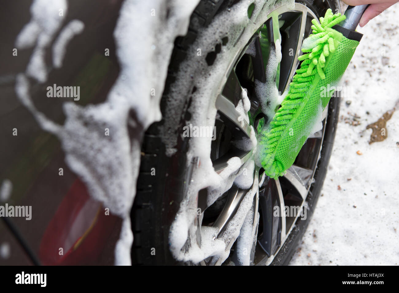 Close Up Of Hand Washing Car Wheel Using Brush Stock Photo