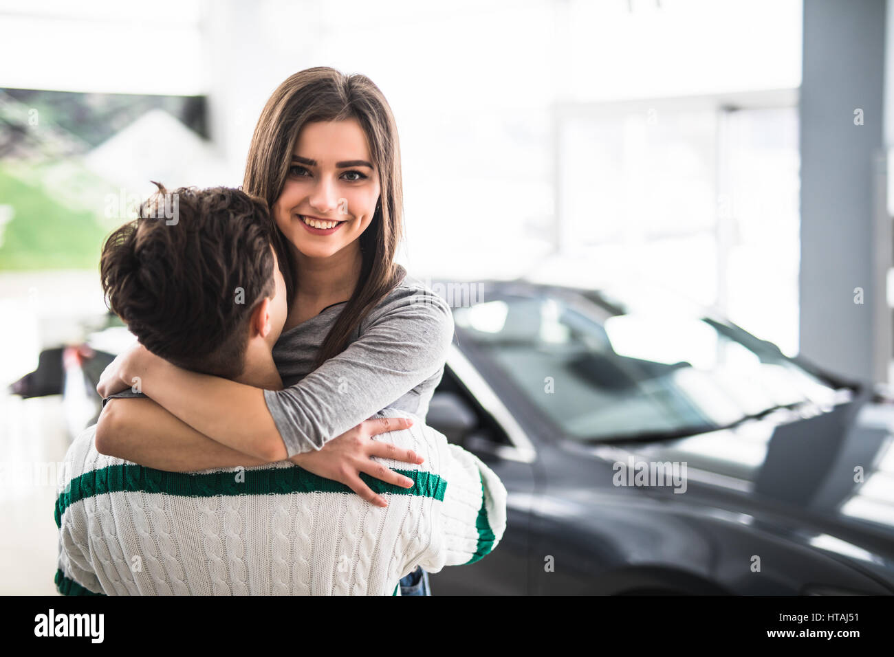 Young woman hugging her boyfriend thanks for the new car Stock Photo ...