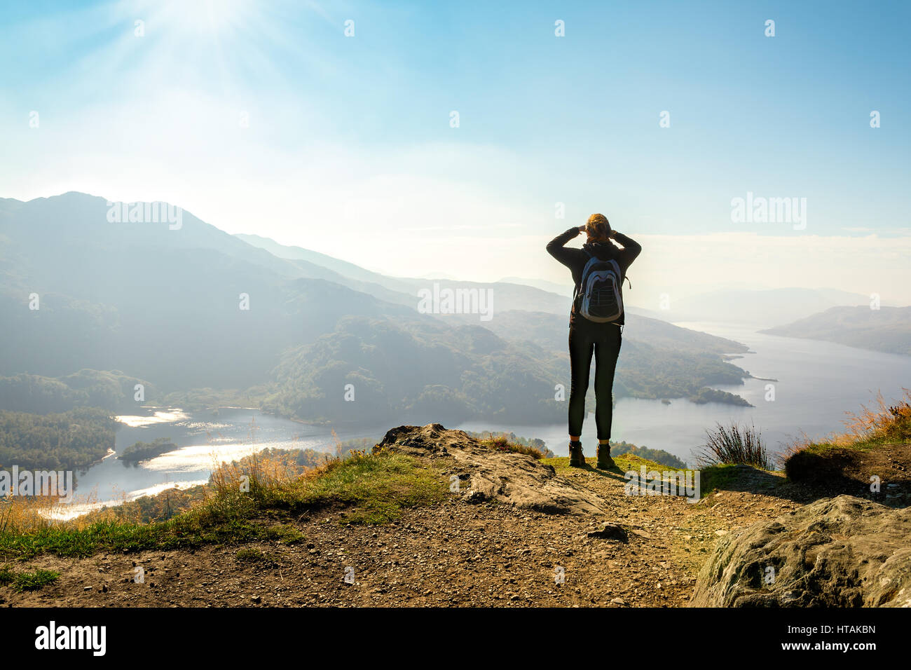 Female hiker on top of the mountain enjoying valley view, Ben A'an, Loch Katrine, Highlands, Scotland, UK Stock Photo