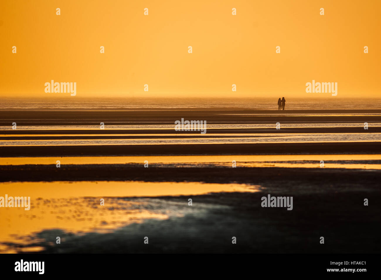 Silhouettes of people at sunset on the beach Stock Photo - Alamy