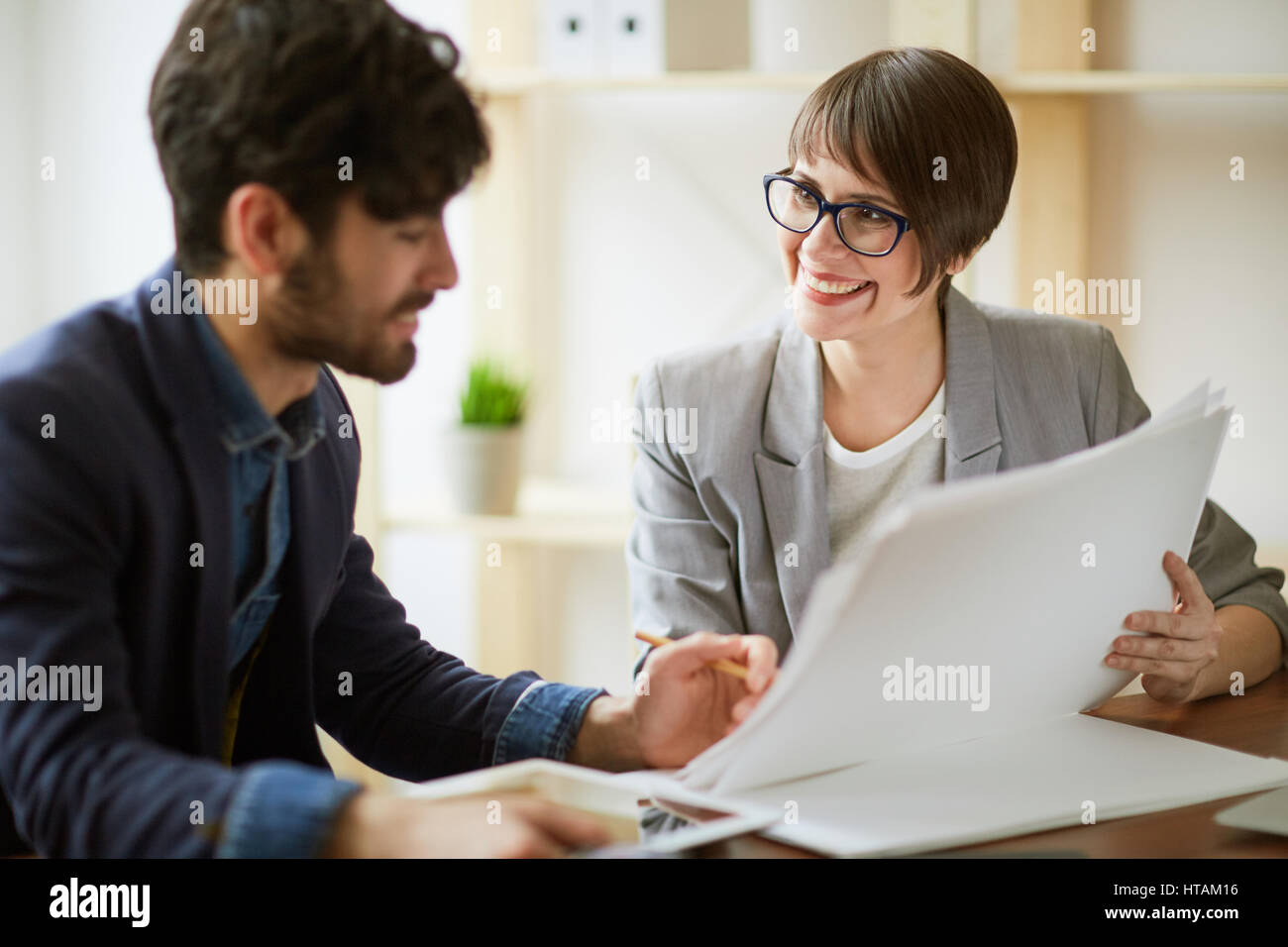 Portrait of two successful business people communicating, making final ...