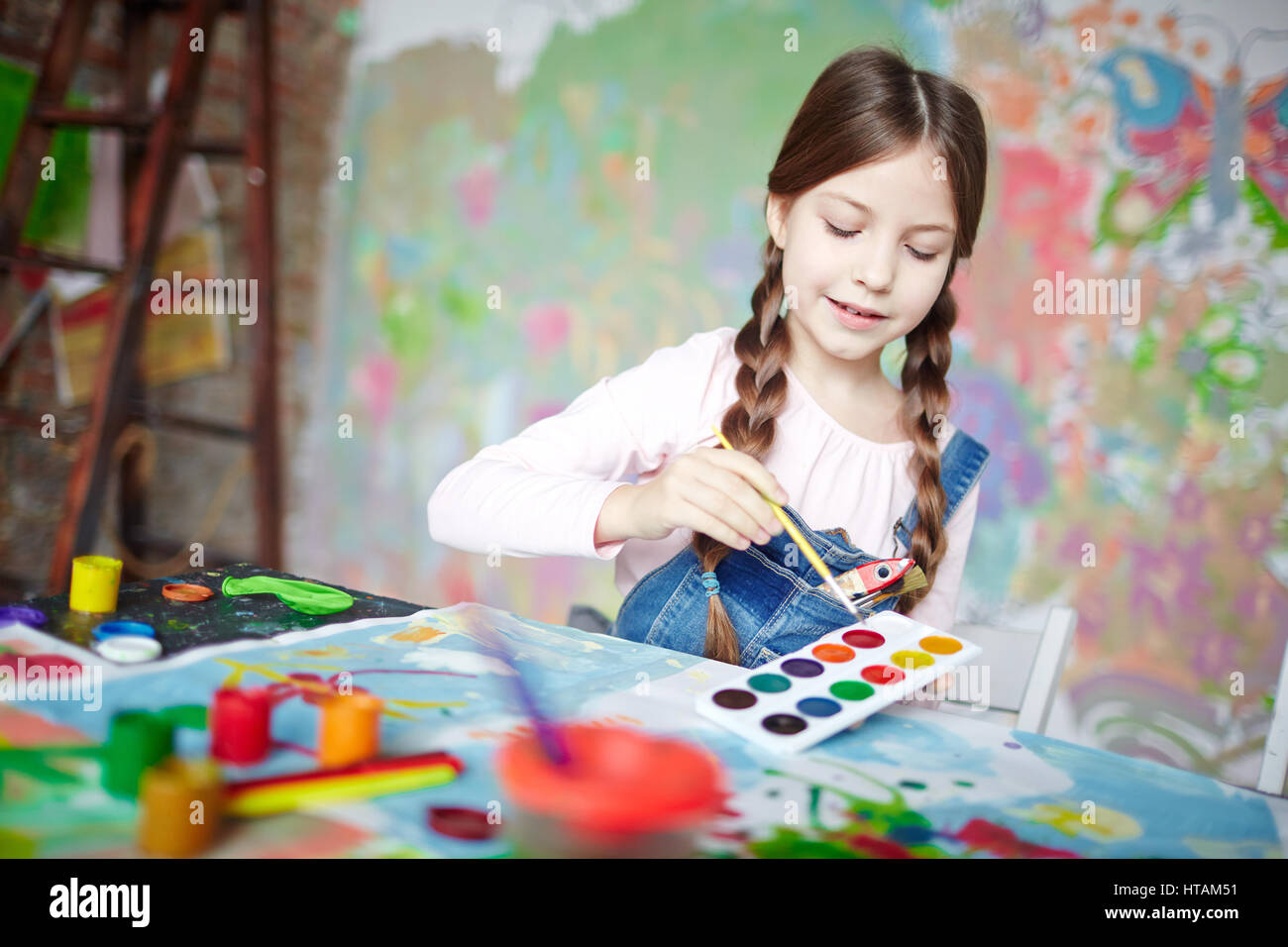 Cute schoolgirl painting with watercolors Stock Photo - Alamy