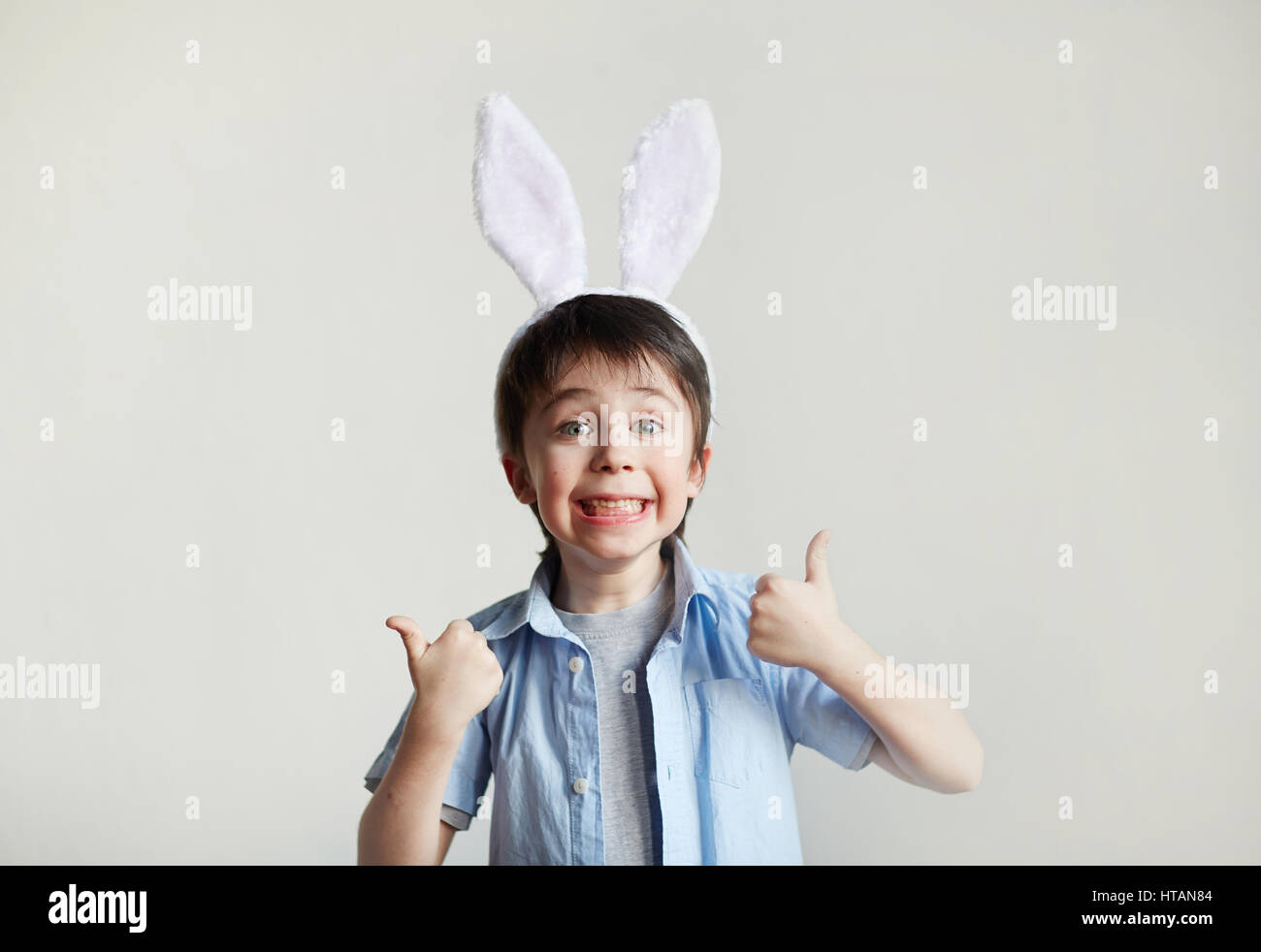 Happy boy showing thumbs up and looking at camera Stock Photo - Alamy