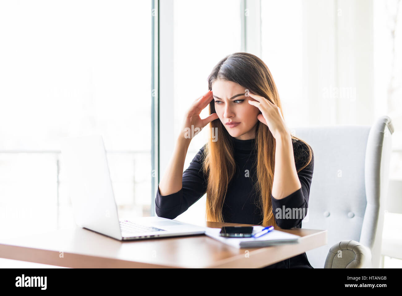 Young attractive woman at modern office desk, working on laptop ...