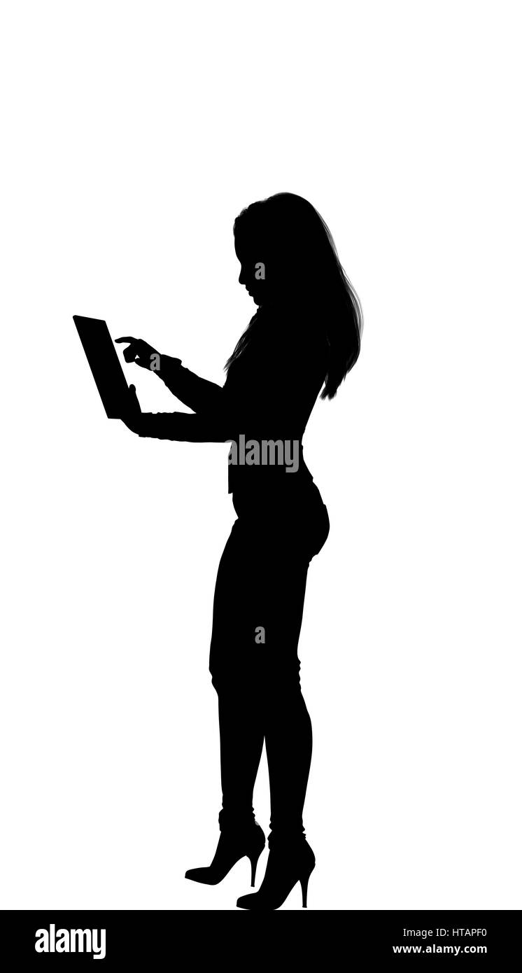 Women standing working on a tablet, long hair, fit, high heel arms on the side, skin classic jeans shirt Stock Photo