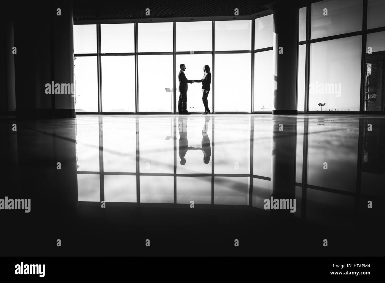 business, teamwork, partnership, cooperation and people concept - business people shaking hands over office background Stock Photo