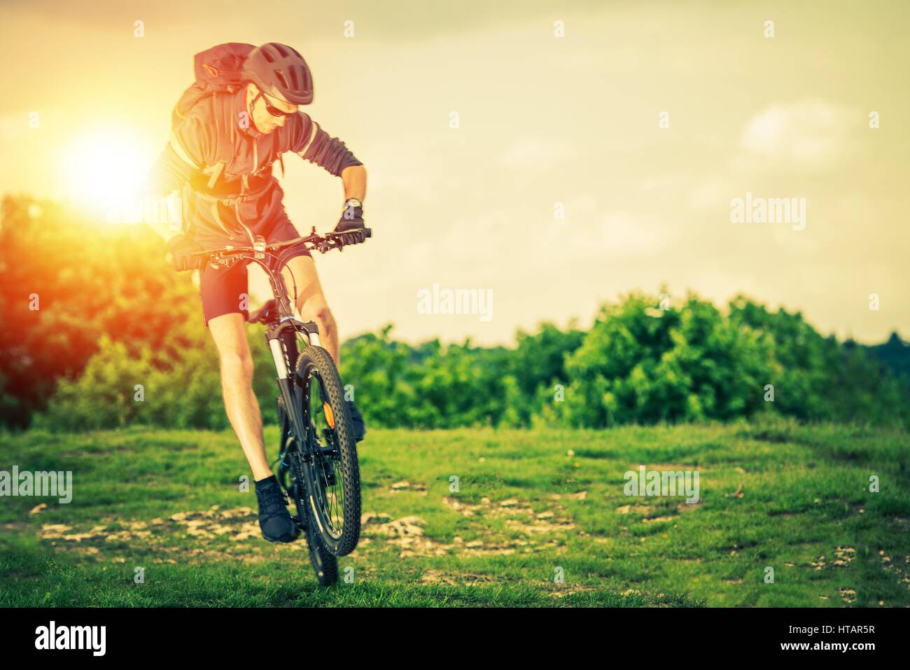 Extreme Mountain Biking. Summer Recreation and Sports Concept. Caucasian Biker. Stock Photo
