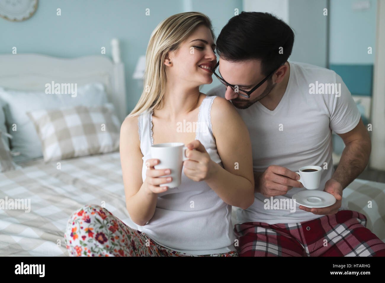 Cute Couple In Love Drinking Coffee In Bedroom Stock Photo
