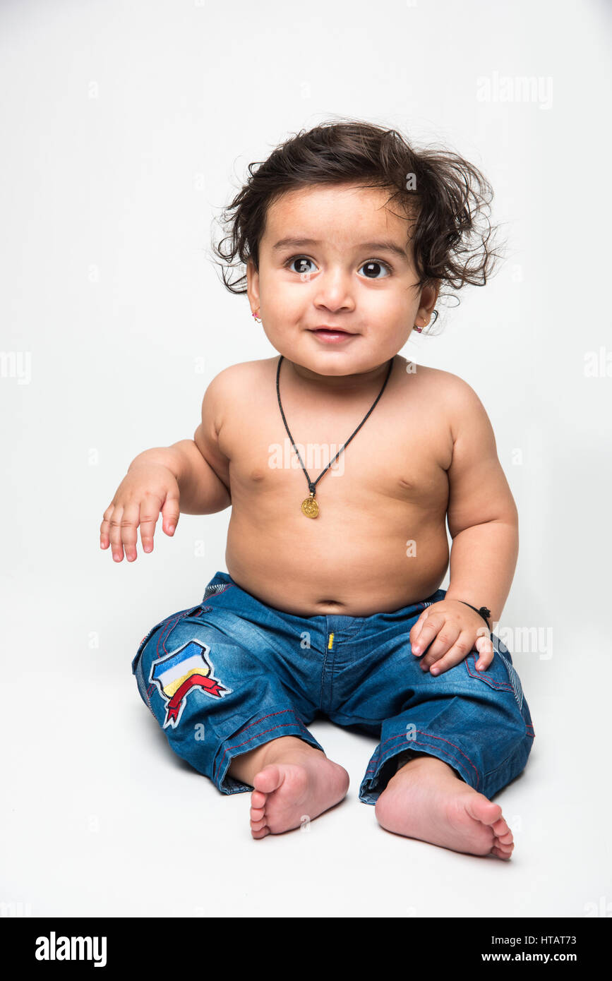 Indian baby boy playing over over white background and looking at ...