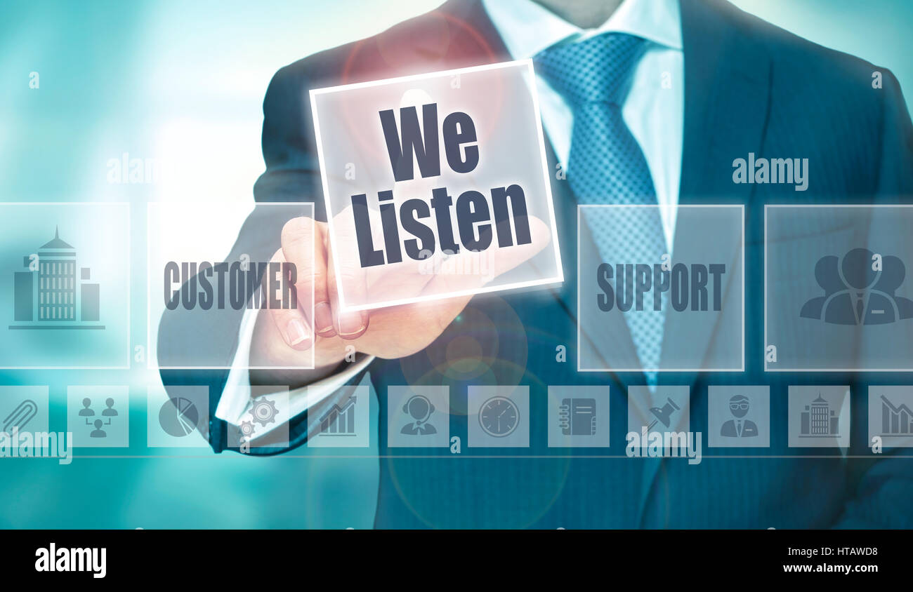 A businessman selecting a We Listen Concept button on a clear screen. Stock Photo