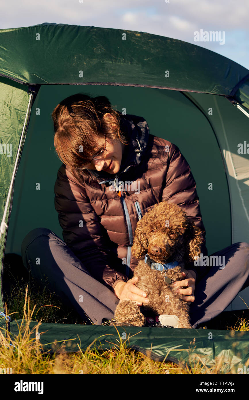 A hiker camping with their dog on the summit of Place Fell in the English Lake District. Stock Photo