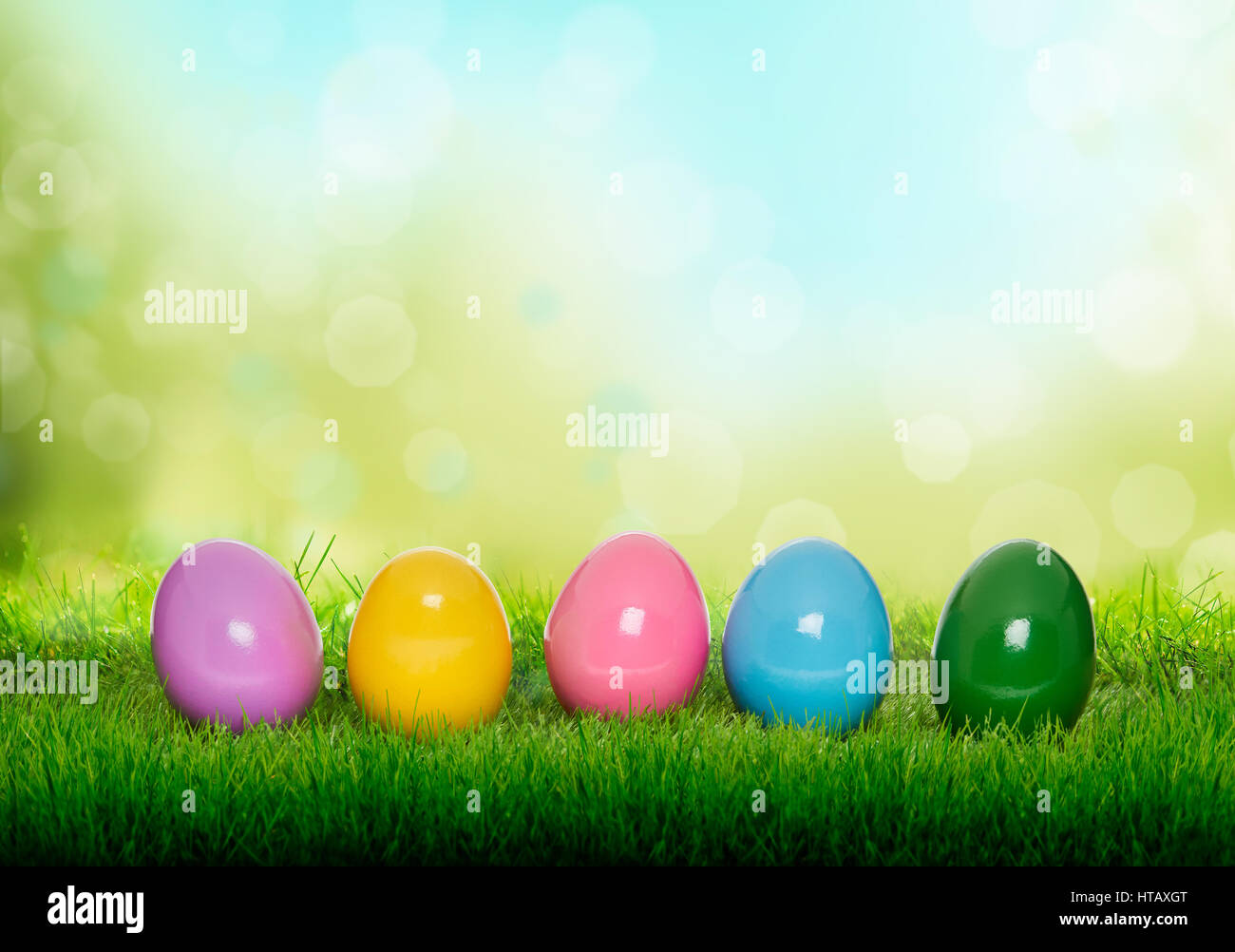 Colourful painted Easter Eggs on green grass and blurred garden ...