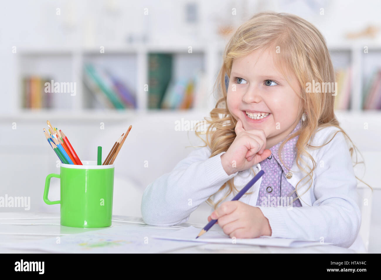 Portrait of a cute little girl drawing with pencils Stock Photo - Alamy