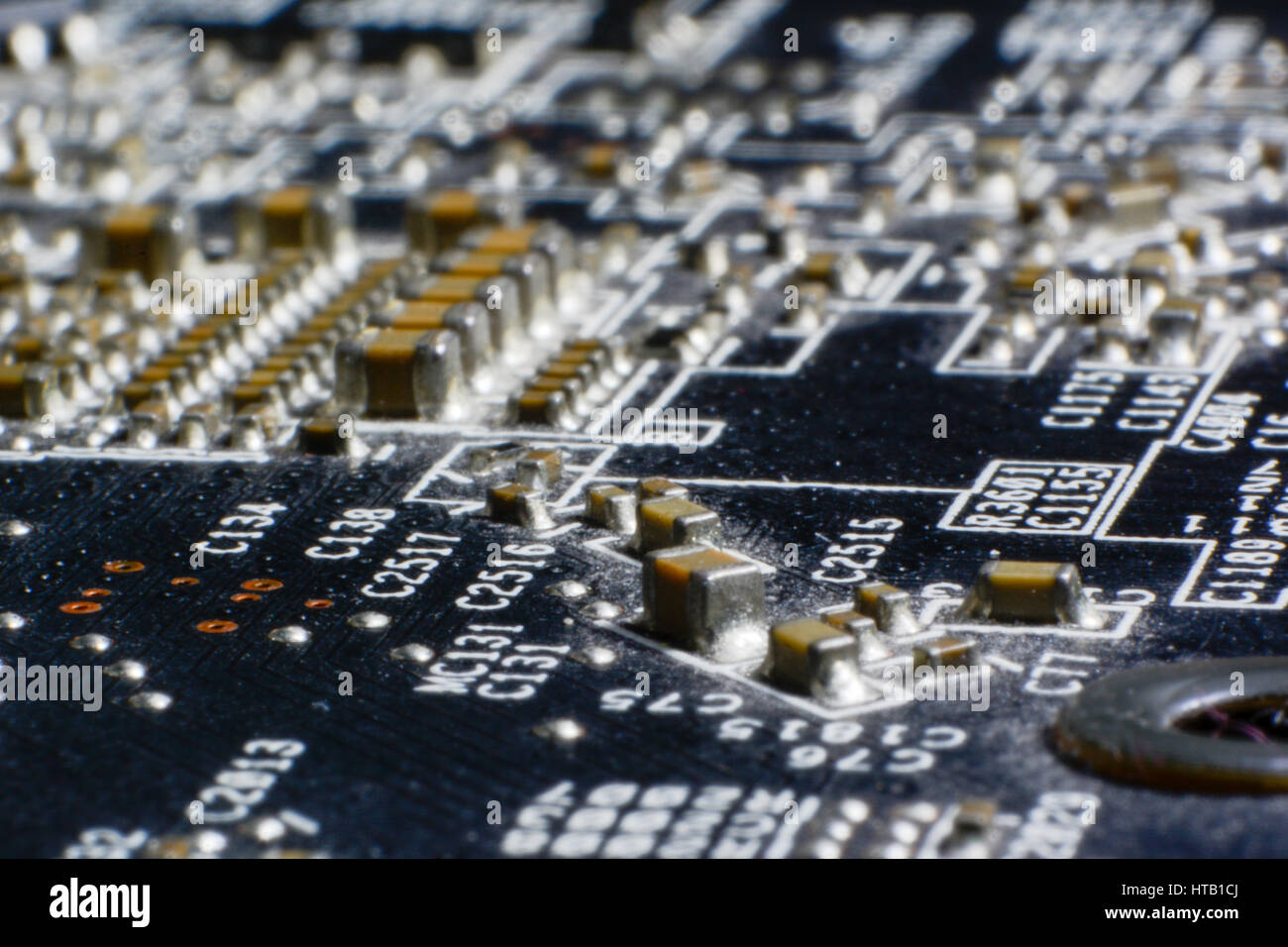 Surface-mount dusty smd components on used electronic circuit board close-up. Stock Photo