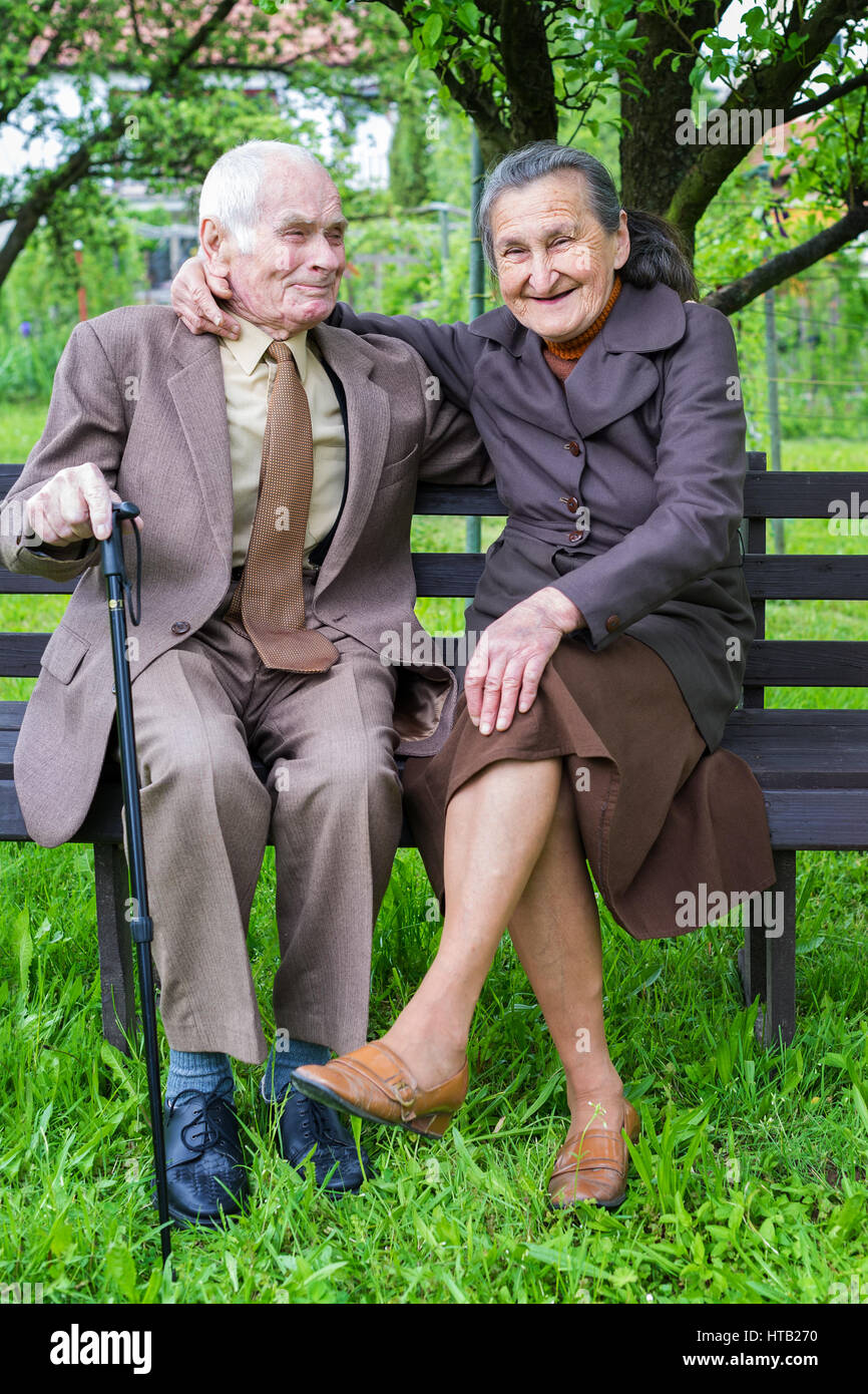 Cute 80 plus year old married couple posing for a portrait in their garden. Love forever concept. Stock Photo