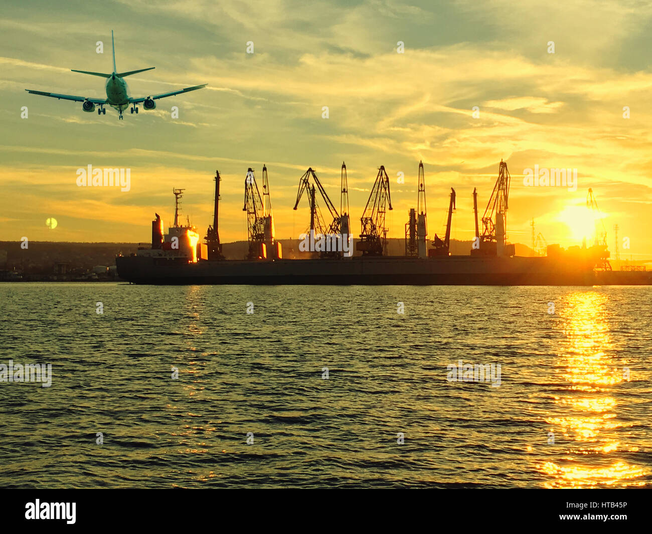 Airplane and silhouettes of cranes and industrial cargo ships in port ...