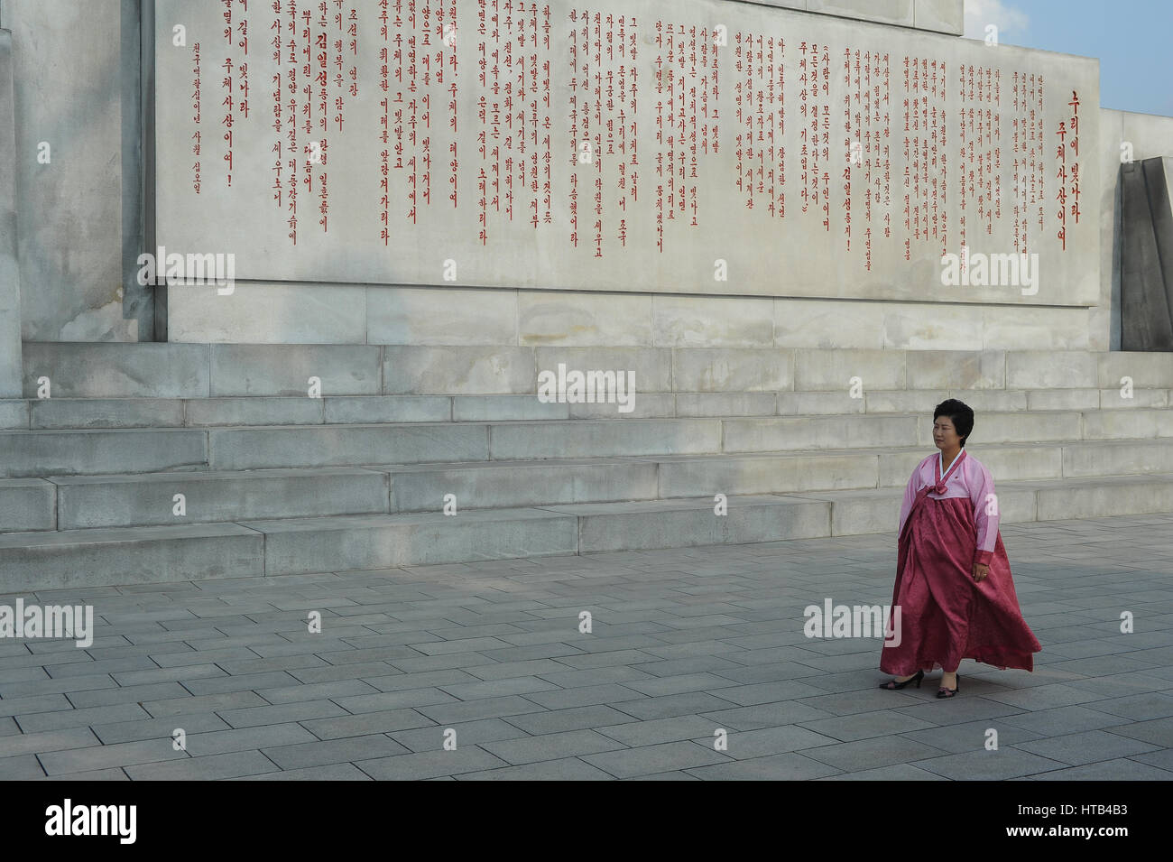 08.08.2012, Pyongyang, North Korea - A North Korean woman wearing a traditional dress is seen at the pedestal of the Tower of Juche. Stock Photo