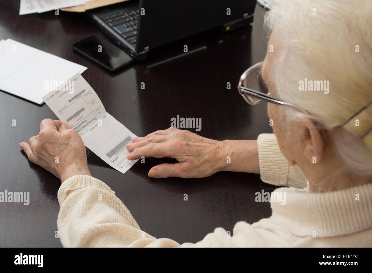 Old woman in doctor's office. The old woman holds in her hands a prescription and reads Stock Photo