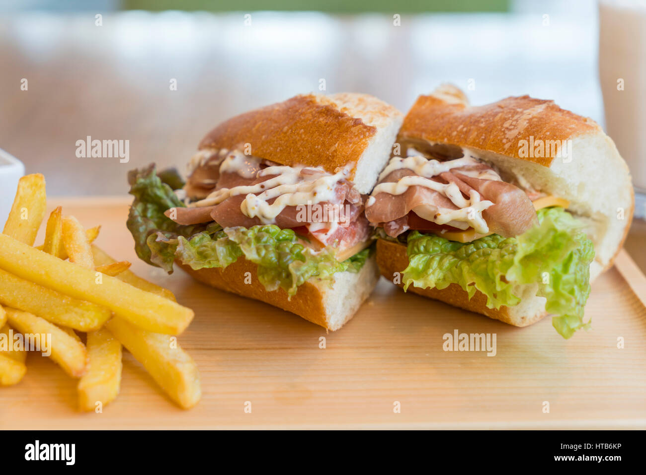 big sandwich with ham, cheese, vegetables and French fries Stock Photo