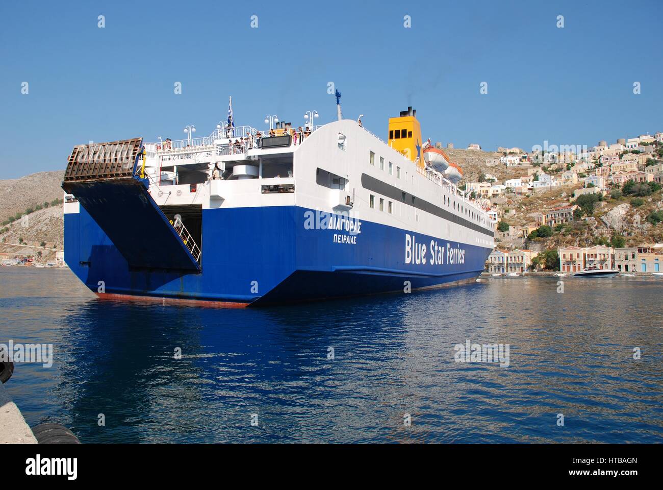 Blue Star Ferries ferry boat Diagoras docking at Yialos harbour on the Greek island of Symi. The 141mtr vessel was built in 1990. Stock Photo