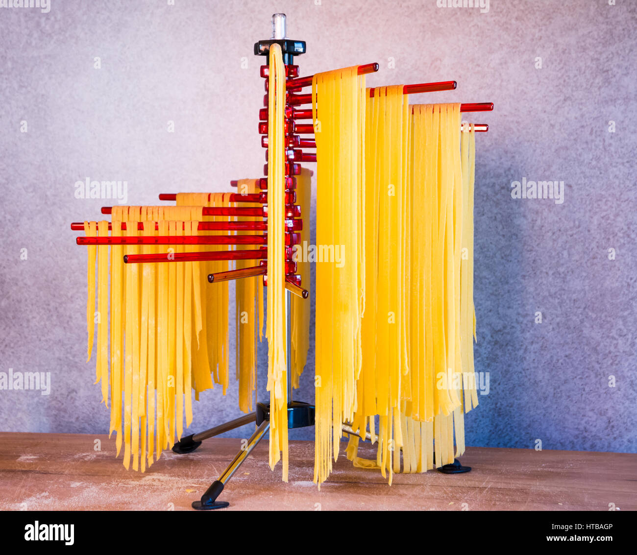 Selfmade italian tagliatelle hanging on a pasta drying rack Stock
