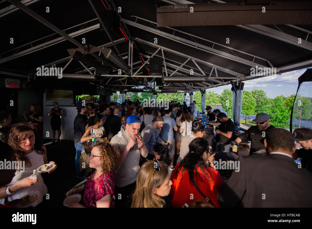people standing under an outdoor tent socializing Stock Photo Alamy