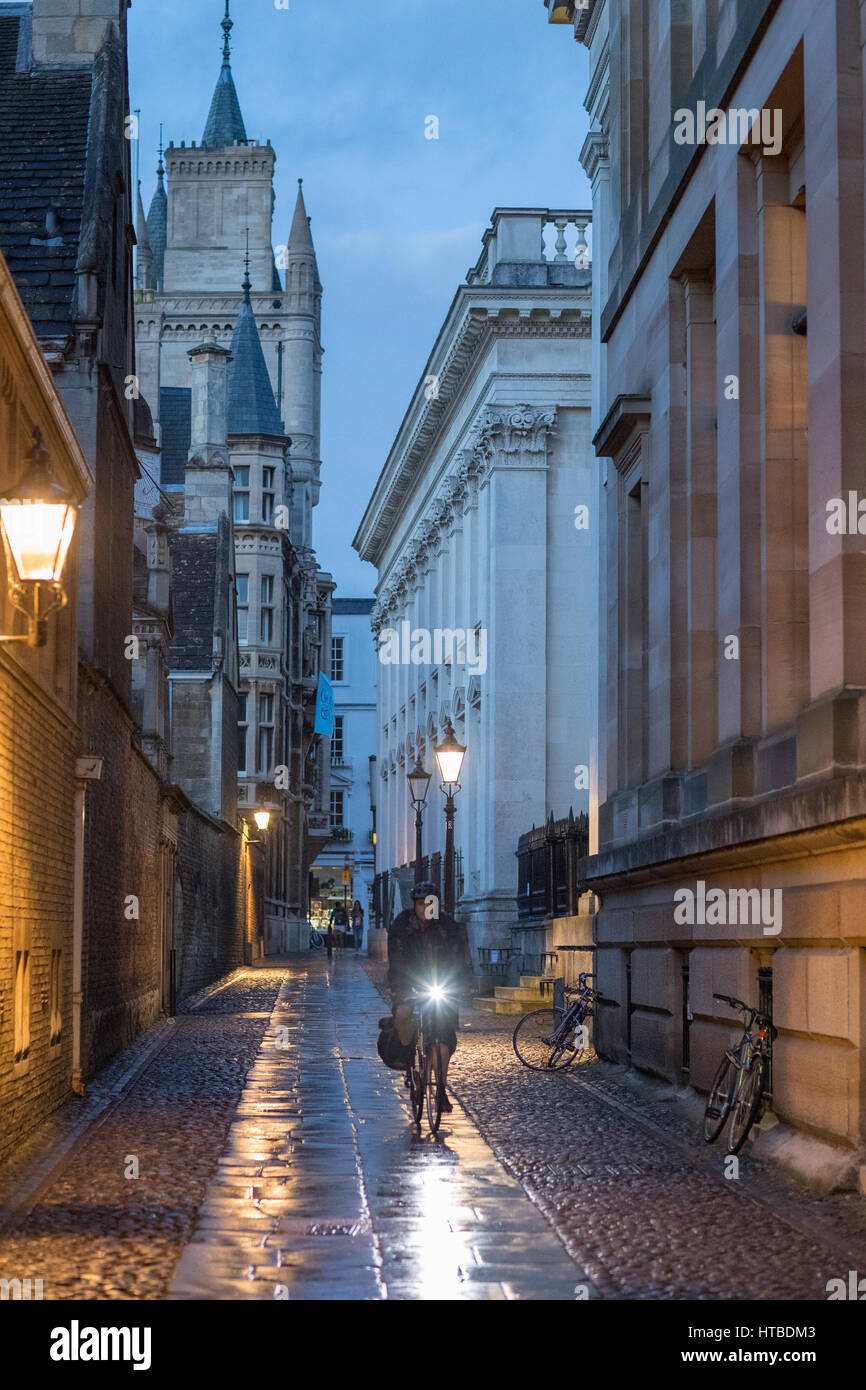 A student cyclist on Senate House Passage at dusk, Cambridge, England, UK Stock Photo