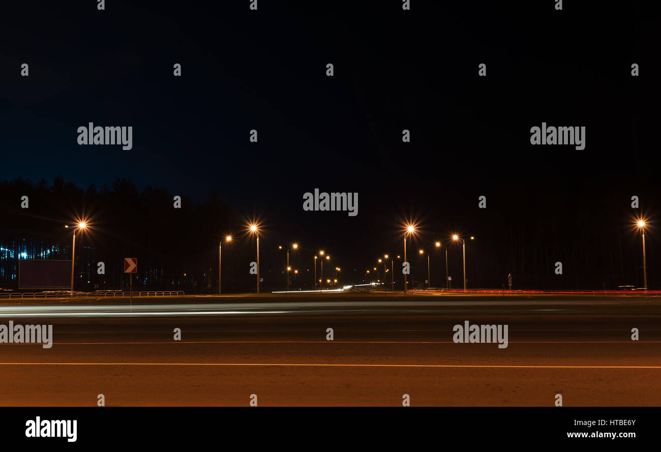 road with car tracks in the night city Stock Photo