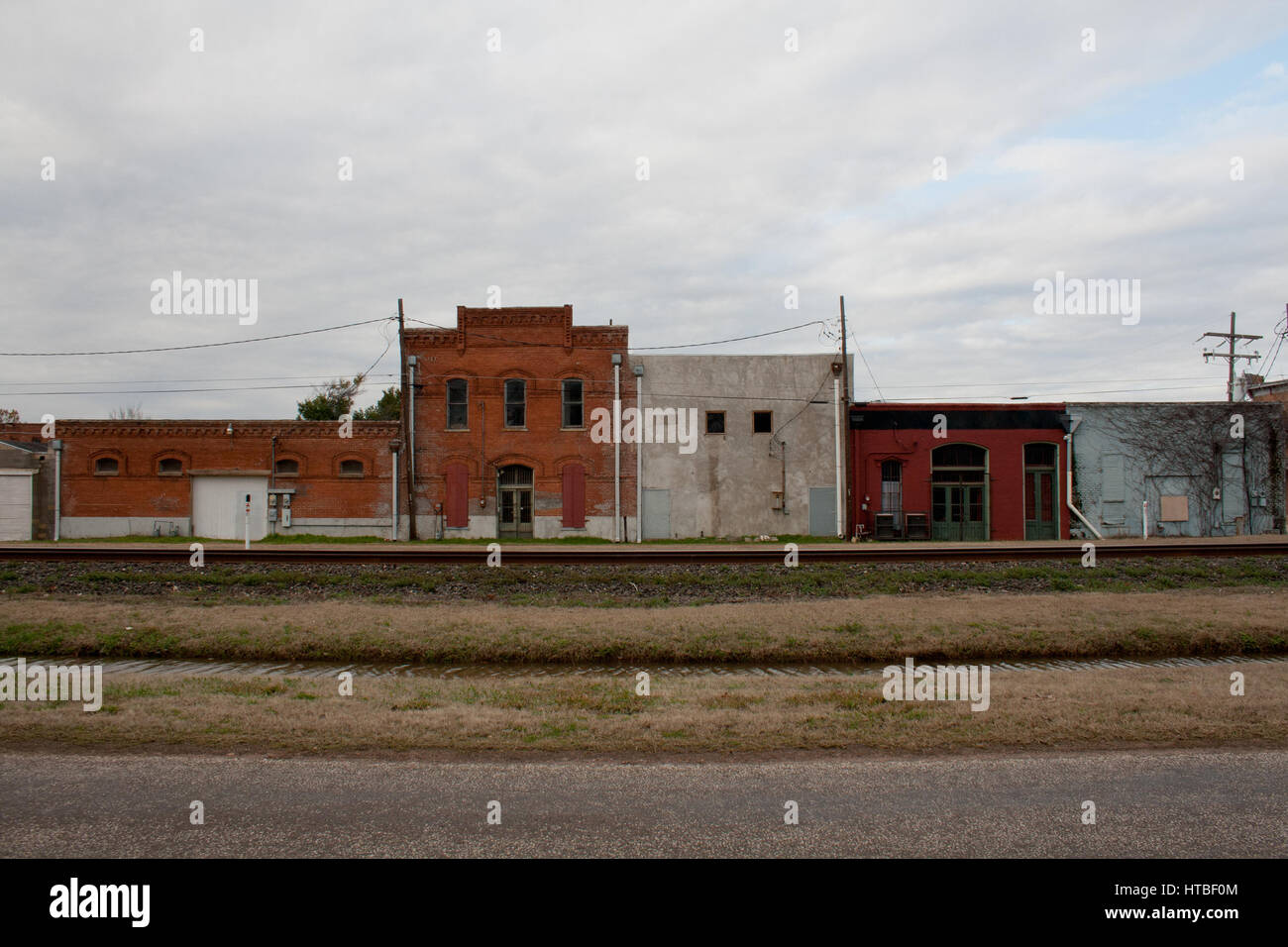 Weathered facades of historic buildings along a railroad track in a rural town in Texas. Stock Photo