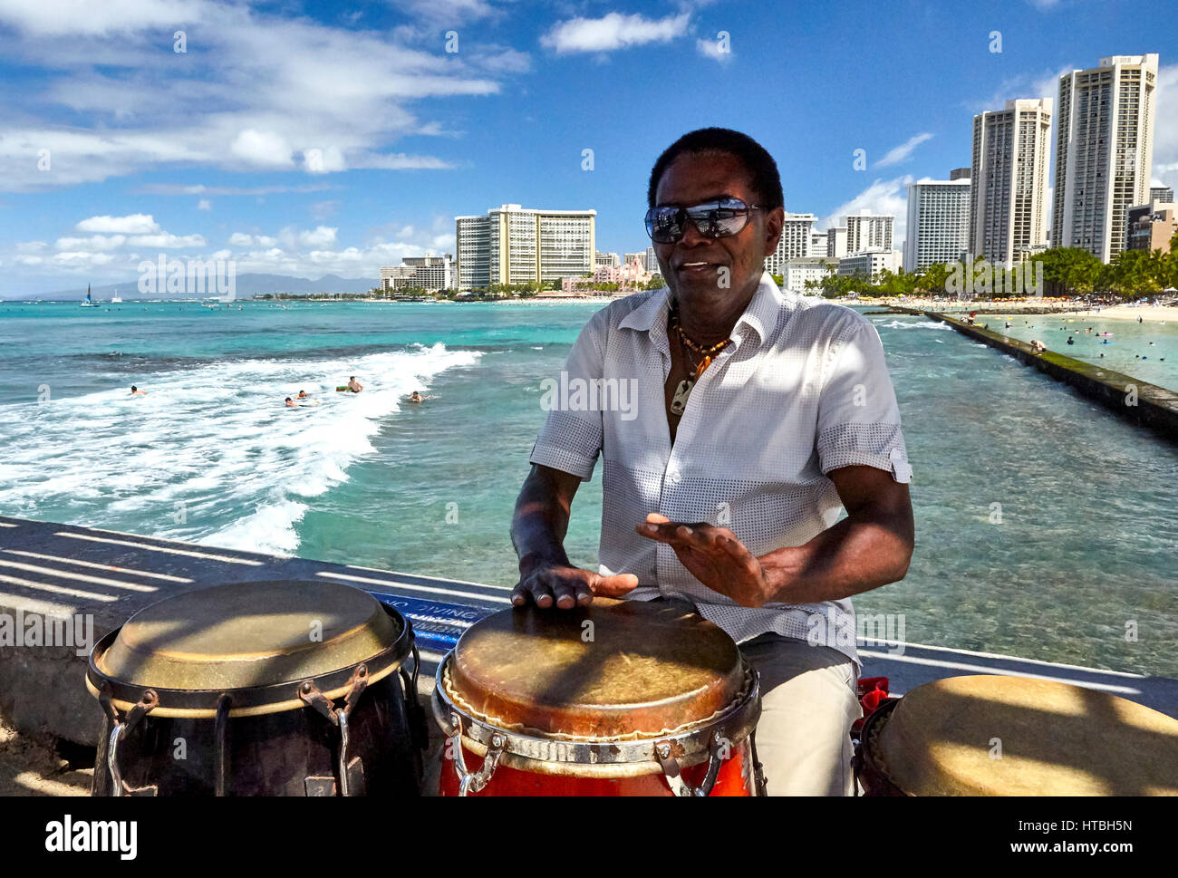 Waikiki Beach, Hawaii, USA - August 2, 2016: Musician and conga drummer Rico Davis entertains tourists and locals in Hawaii. Stock Photo