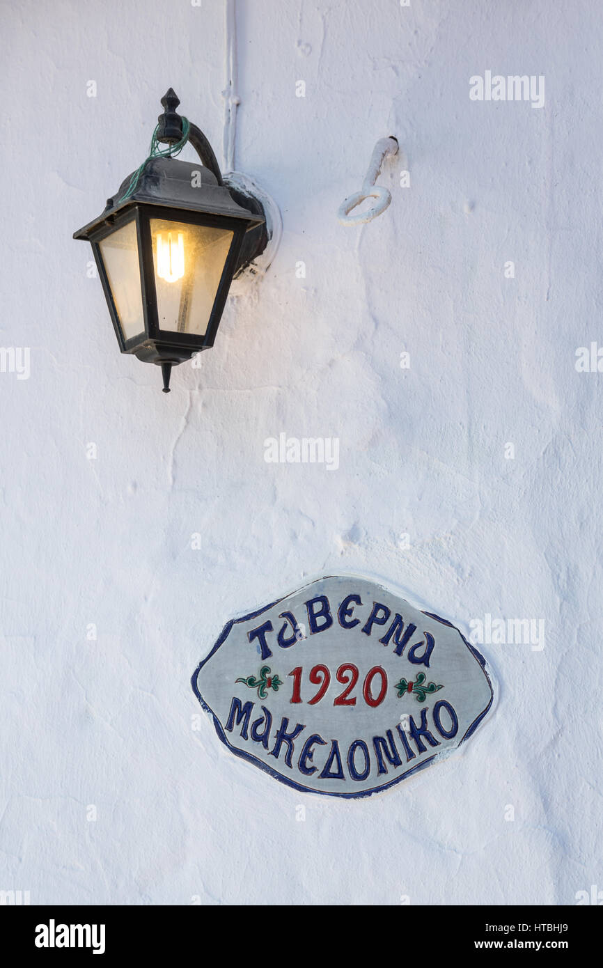 Traditional ceramic art sign of greek tavern on a white wall Stock Photo
