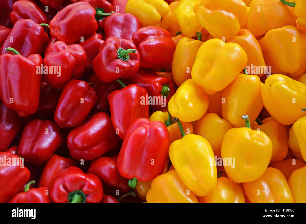 Red and yellow bell peppers in a pile at a farm stand; United States of ...