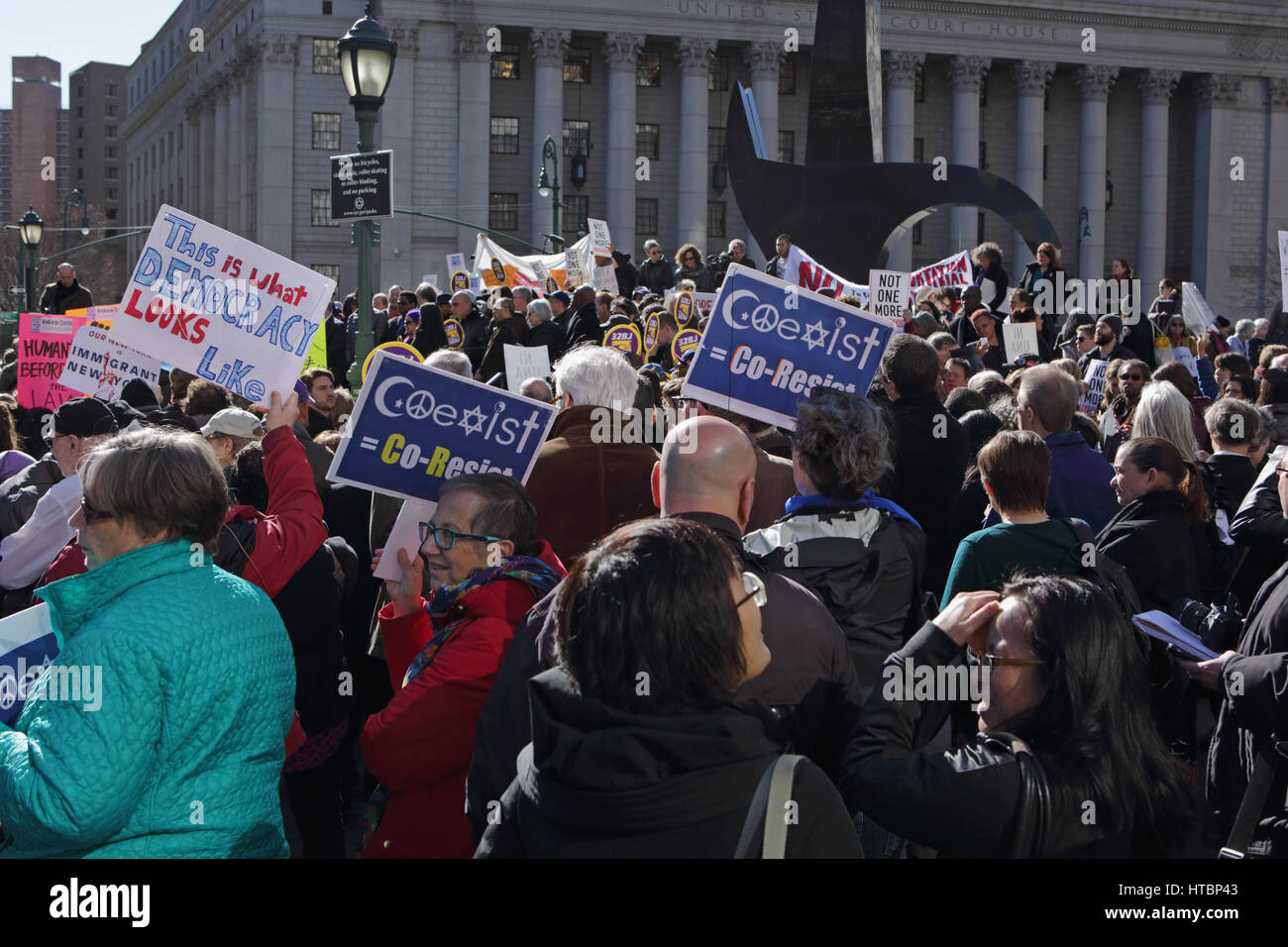 New York, NY, USA - March 9, 2017: A group of about 100 people rally in Foley Square, outside a courthouse in Manhattan, to protest Trump travel ban Stock Photo