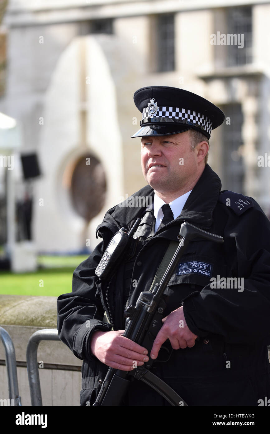 Armed policeman outside the Ministry of Defence building in Whitehall, London, UK. Space for copy Stock Photo