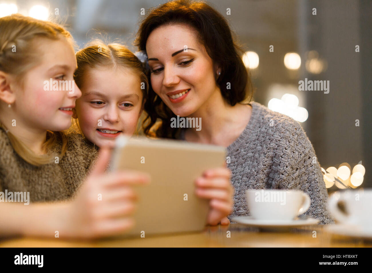 Little twins with touchpad and their mother having online entertainment Stock Photo