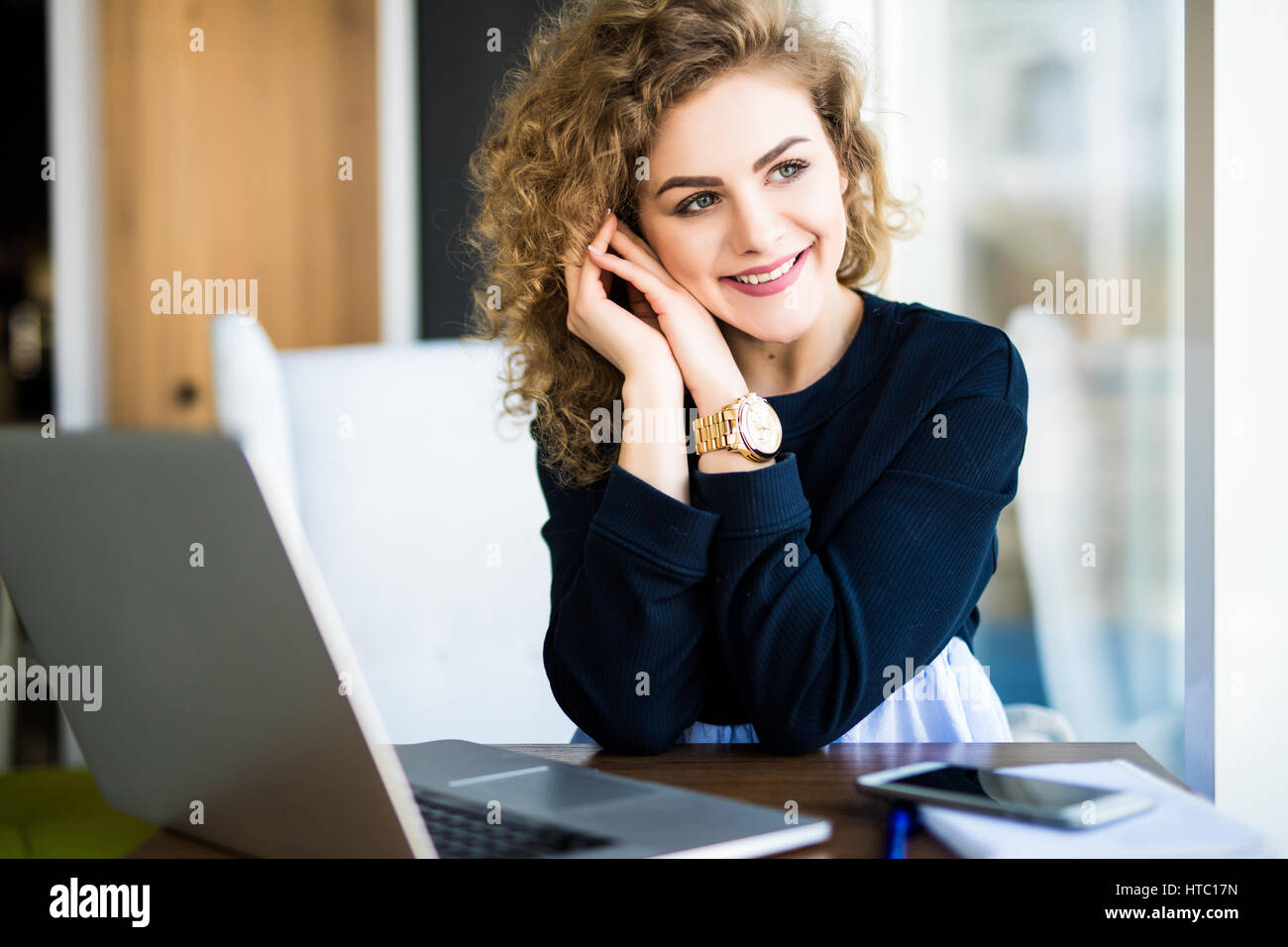 Young attractive woman at a modern office desk, working with laptop ...