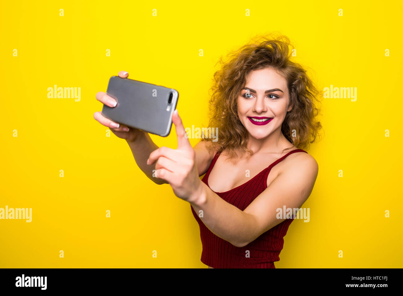 Young Beautifulgirl With An Curly Hairstyle Laughing Girl Take Selfie From Phone On Yellow