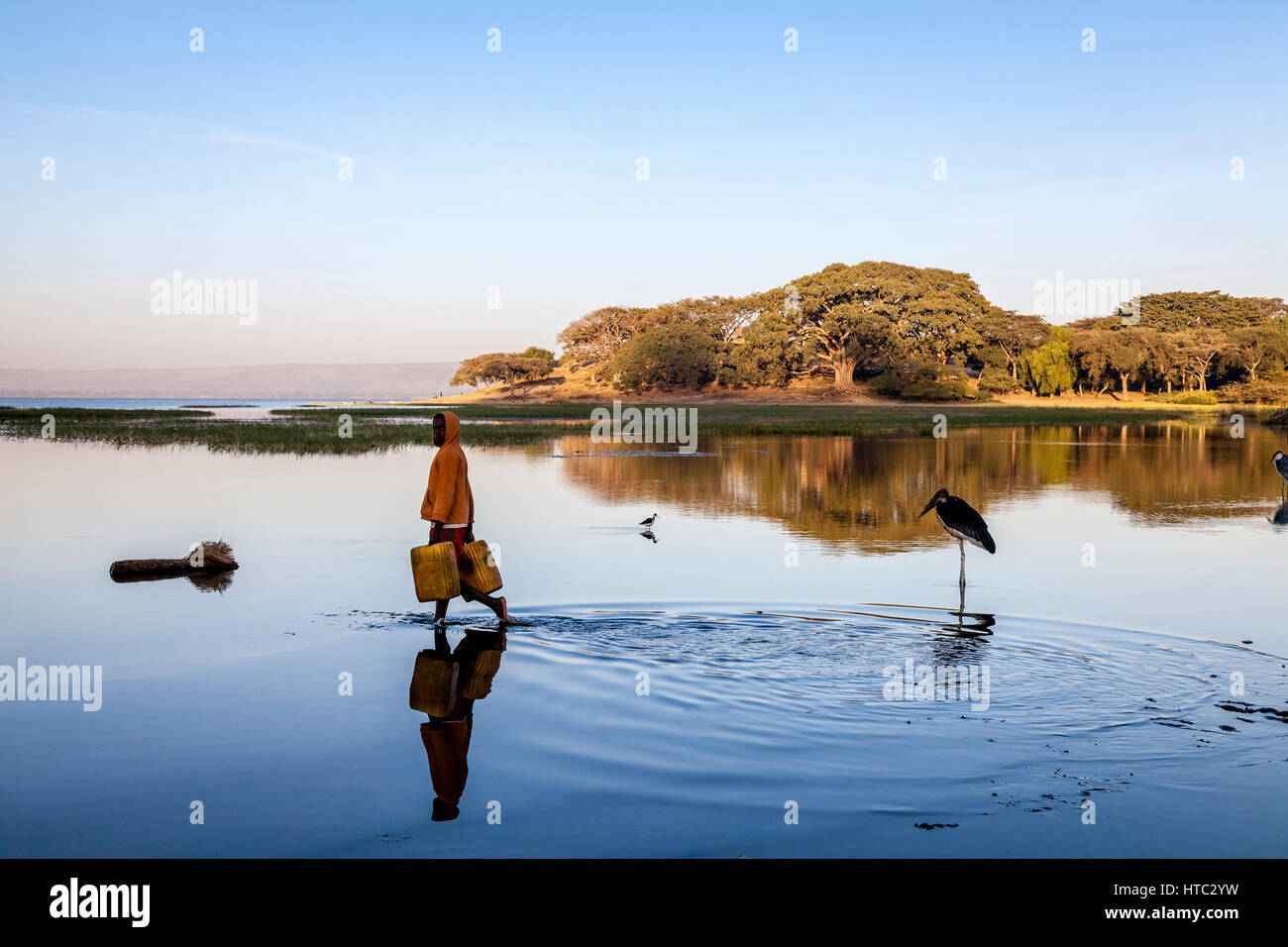 A Teenage Boy Collects Water From The Lake In Containers, Lake Awassa, Ethiopia Stock Photo
