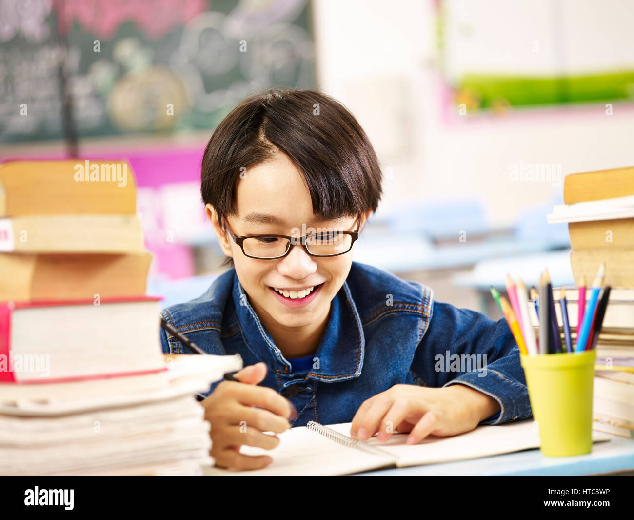 happy asian elementary school boy studying in classroom smiling. Stock Photo