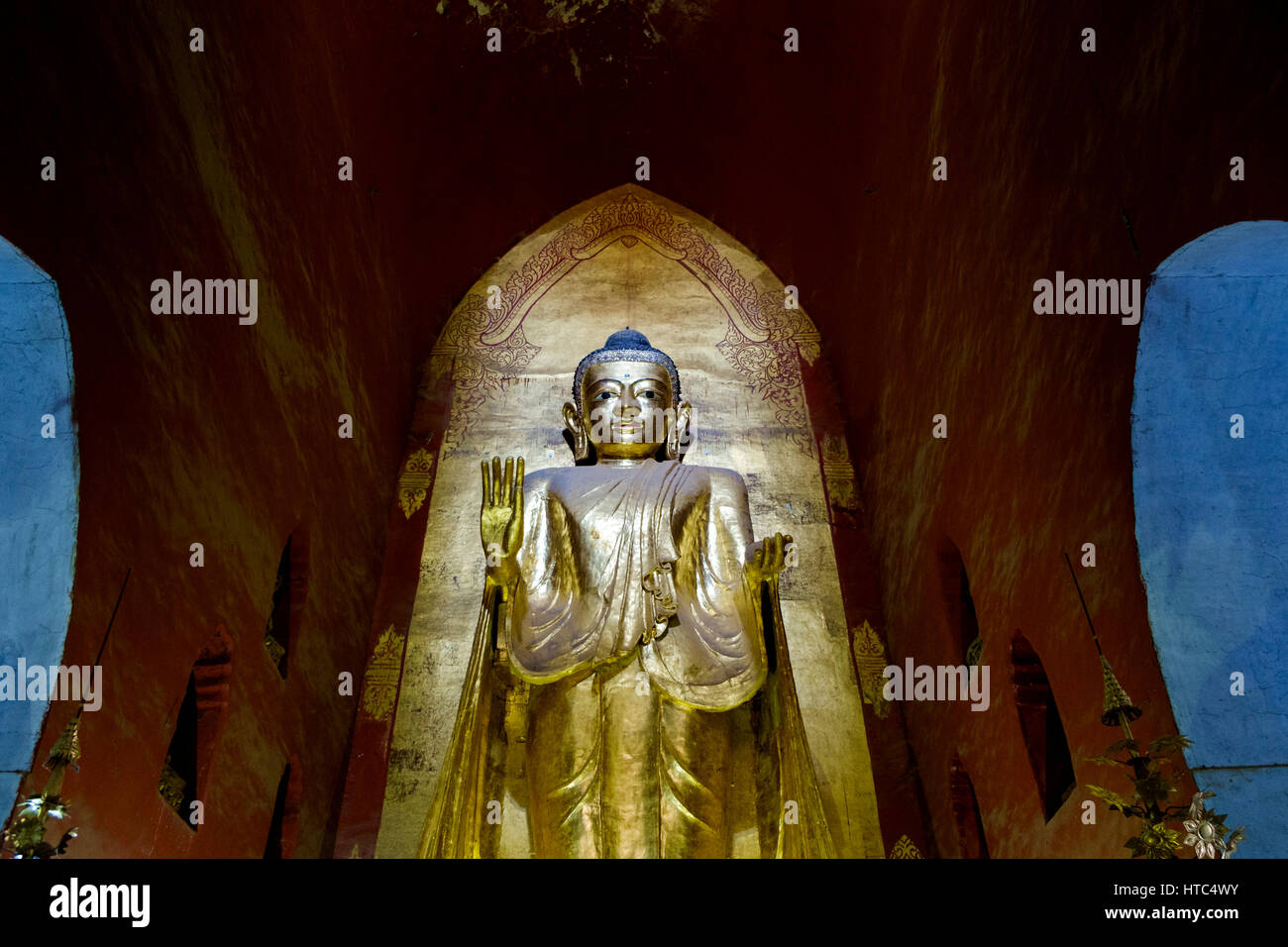 One of the four gilded teak standing Buddha images at Ananda Temple, Bagan, Myanmar. Stock Photo