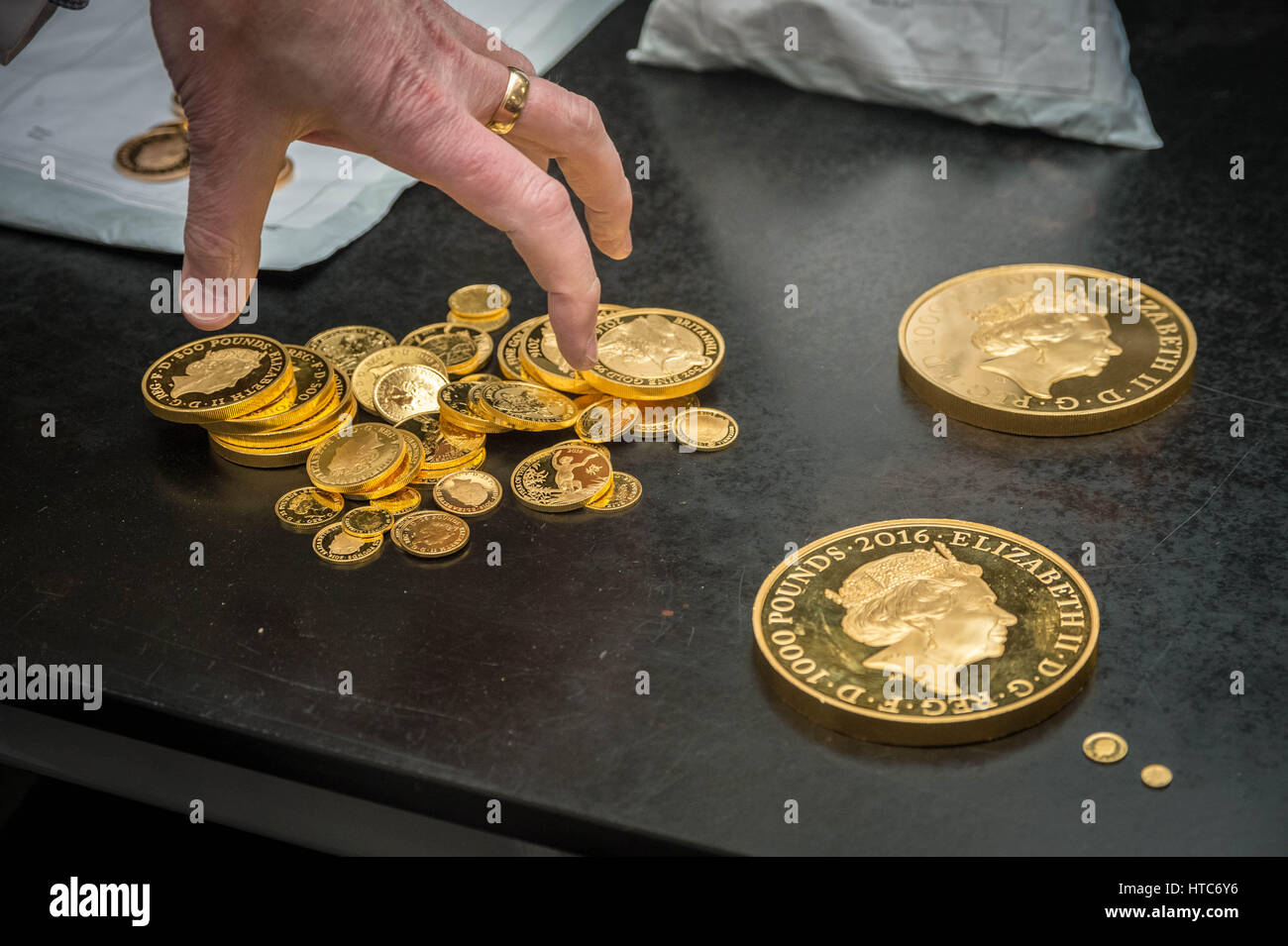 As well as standard coins, the London Assay office also tests commemorative coins. Pictured here a mix of pure gold 999 proof sovereign coins. Stock Photo