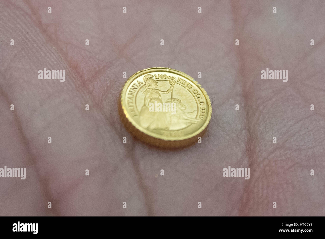 As well as standard coins, the London Assay office also tests commemorative coins. Pictured here a tiny 1/40oz pure gold 999 proof coin. Stock Photo