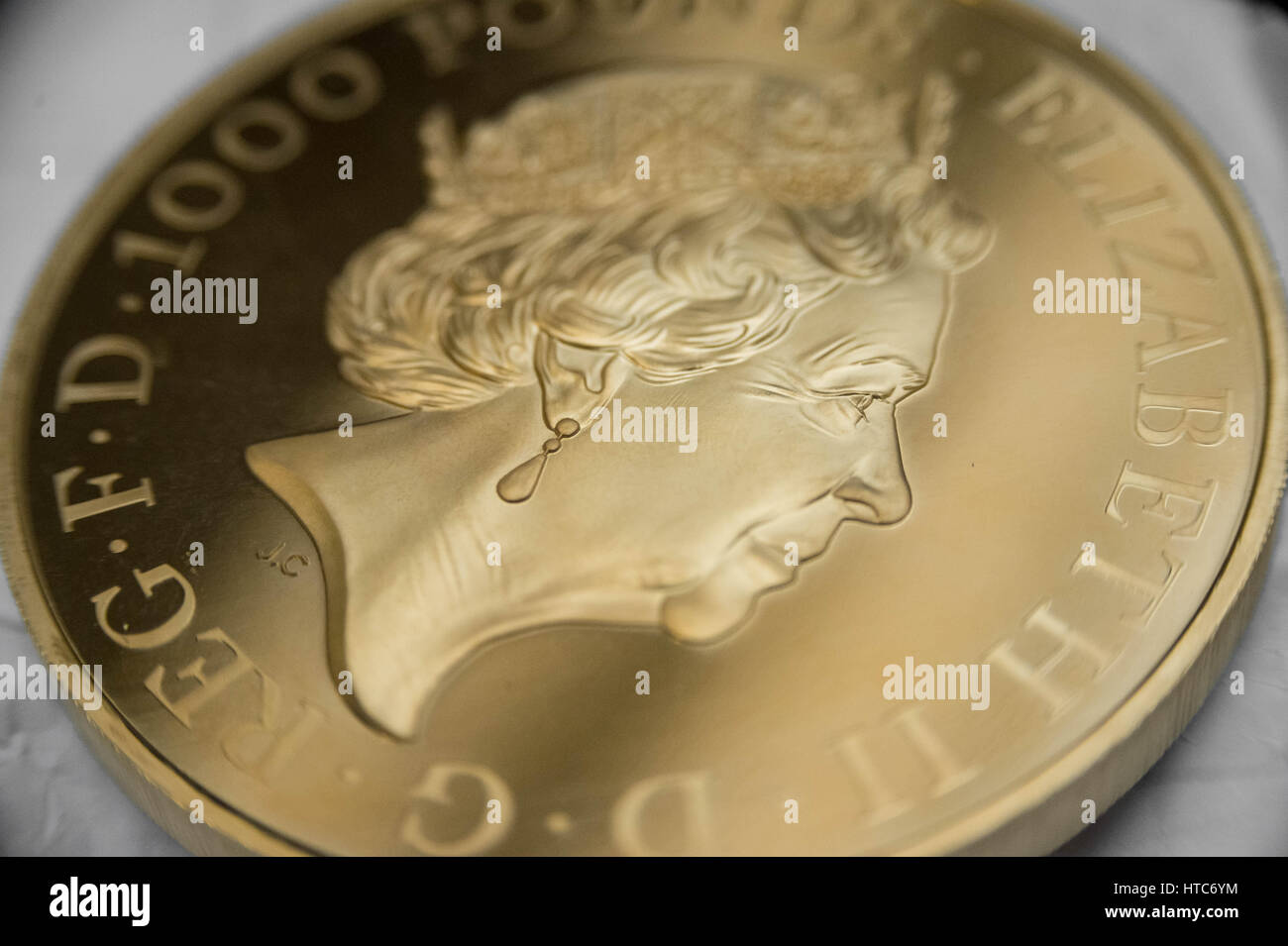 As well as standard coins, the London Assay office also tests commemorative coins. Pictured here a pure gold 999 proof sovereign coin. Stock Photo