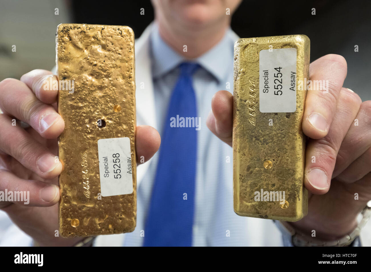 A bar of pure gold melted together from scrap gold bits held by Chris Walne, Lab Manager, at The Goldsmiths' Company Assay Office. London, UK. Stock Photo