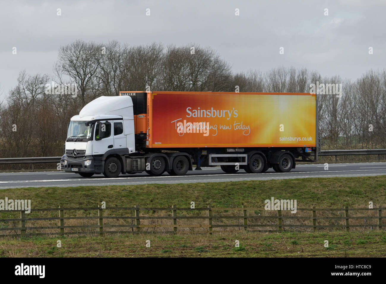 Distribution, transportation & logistics - articulated lorry (heavy goods vehicle HGV, Sainsbury's slogan) travelling on A1 motorway - England, GB UK. Stock Photo