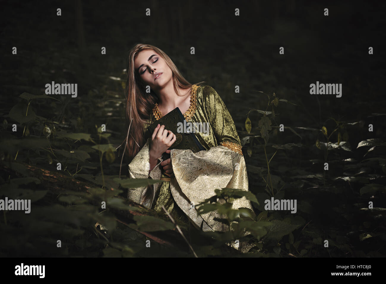 Woman with eyes closed in dark fairy forest. Fantasy story Stock Photo