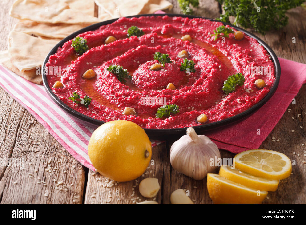 Hummus of beet, chickpeas and pita bread closeup on table. Horizontal