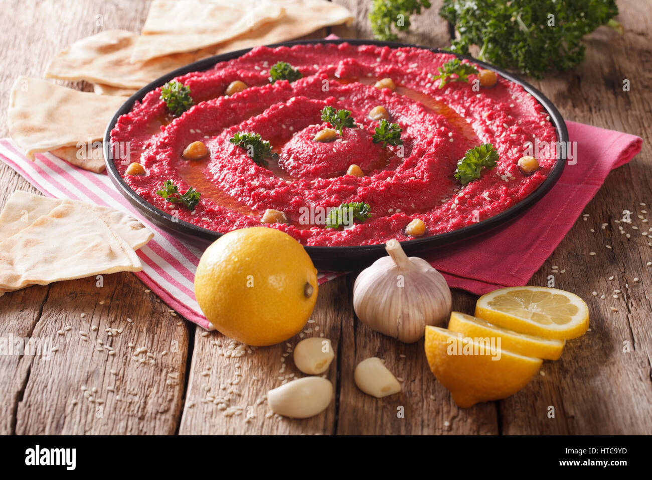 Hummus of chickpeas and beetroot and ingredients close-up on the table. Horizontal Stock Photo