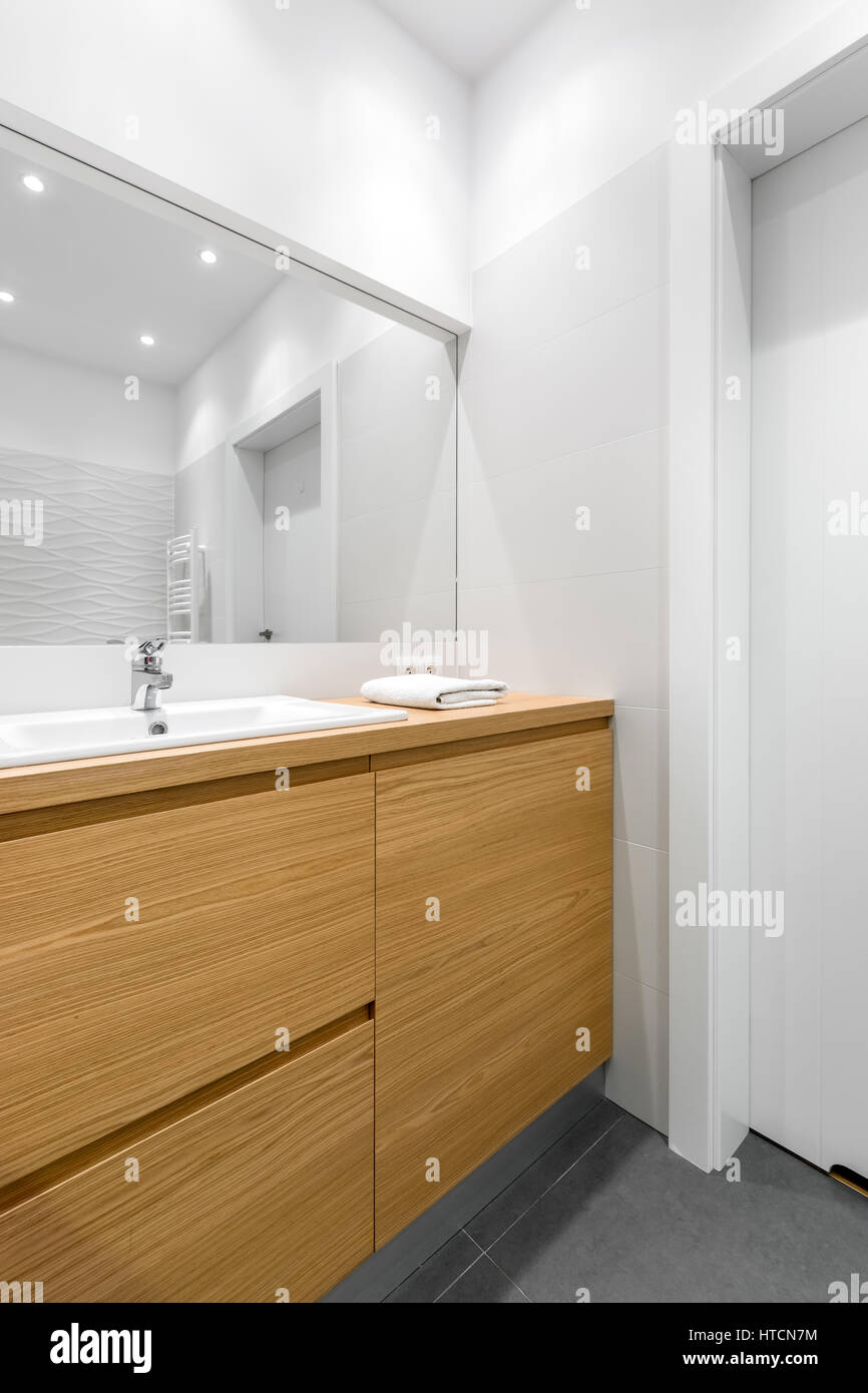 Wide mirror over wood in clean, white bathroom Stock Photo Alamy